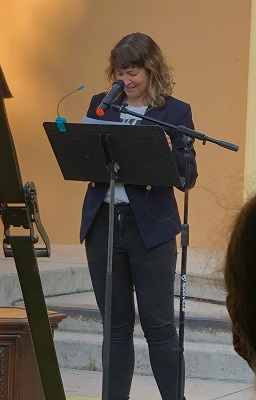 Suzanne Garcia Pino stands by a microphone and reads her work at Second Wind.